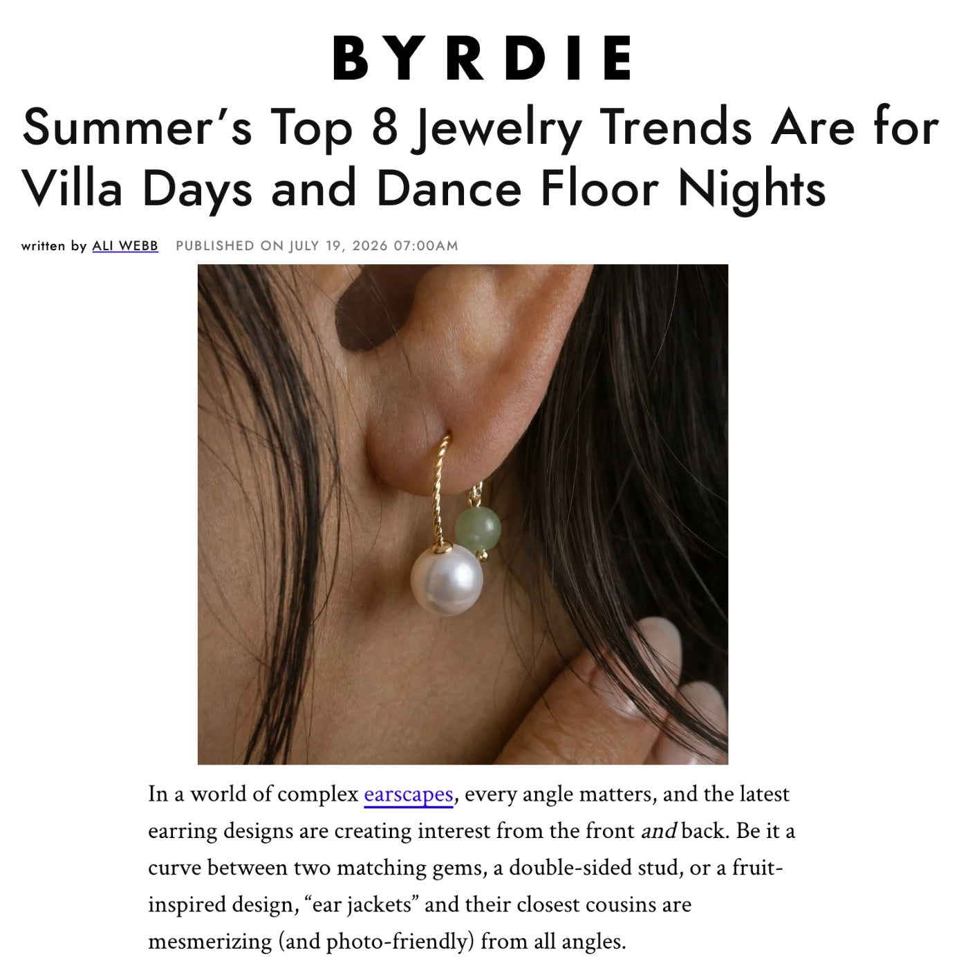 A digital article preview from BYRDIE featuring a close-up photo of a person's ear wearing a gold double-sided stud earring with a green gem and a white pearl, with the headline 'Summer's Top 8 Jewelry Trends Are for Villa Days and Dance Floor Nights'.