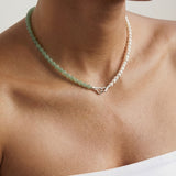 Beaded necklace featuring green and silver beads on a person with a neutral background