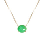 A delicate gold chain necklace featuring a small, oval-cut green gemstone pendant in a four-prong setting, shown against a plain white background.