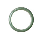 A flat lay shot of a single smooth, polished jadeite bangle bracelet in a soft light green color, shown against a plain white background.