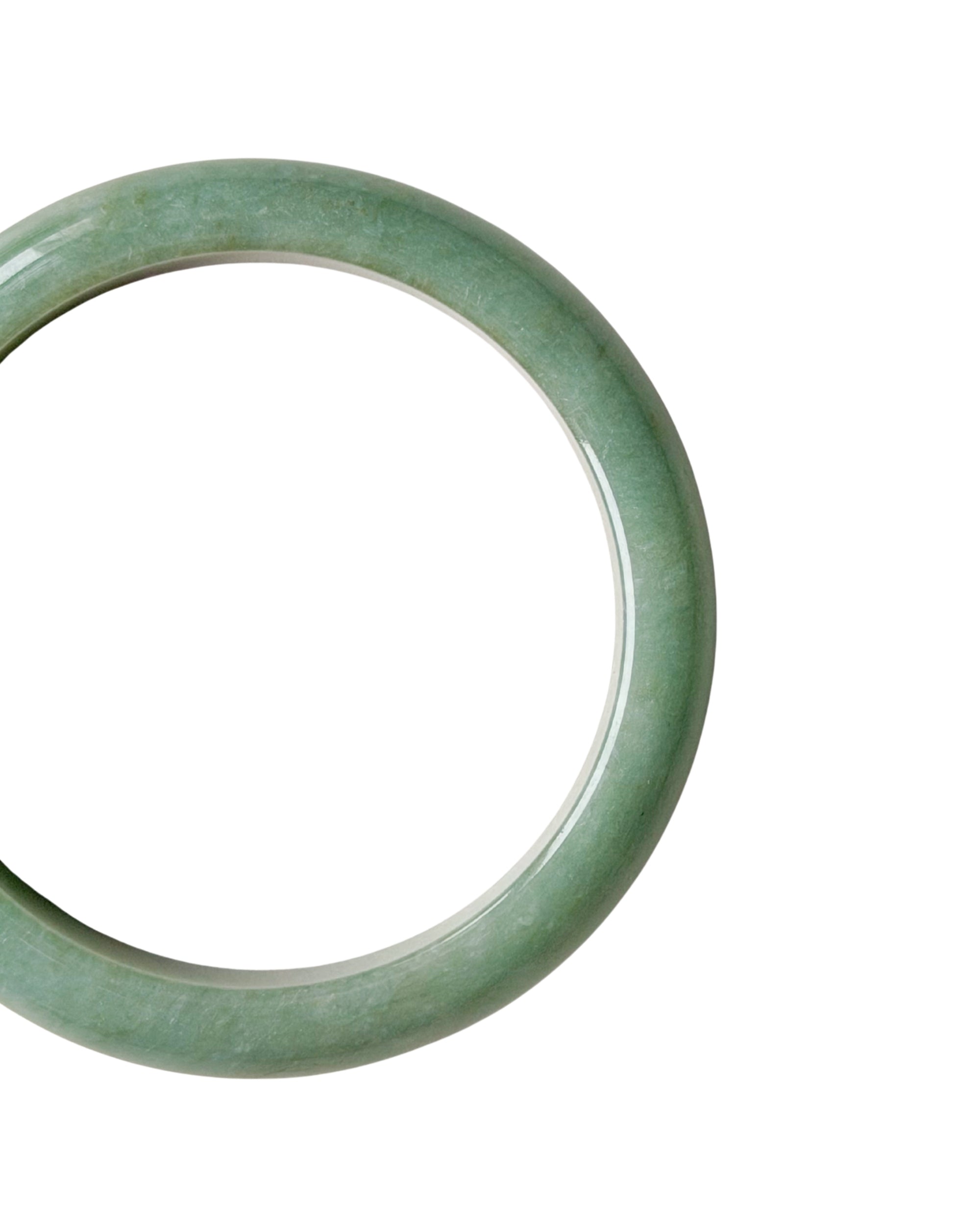A close-up shot of a single light green jade bangle bracelet shown on a plain white background.