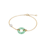 A delicate gold chain bracelet featuring a central light green jade-like ring and a single white pearl bead on the opposite side, displayed on a clean white background.