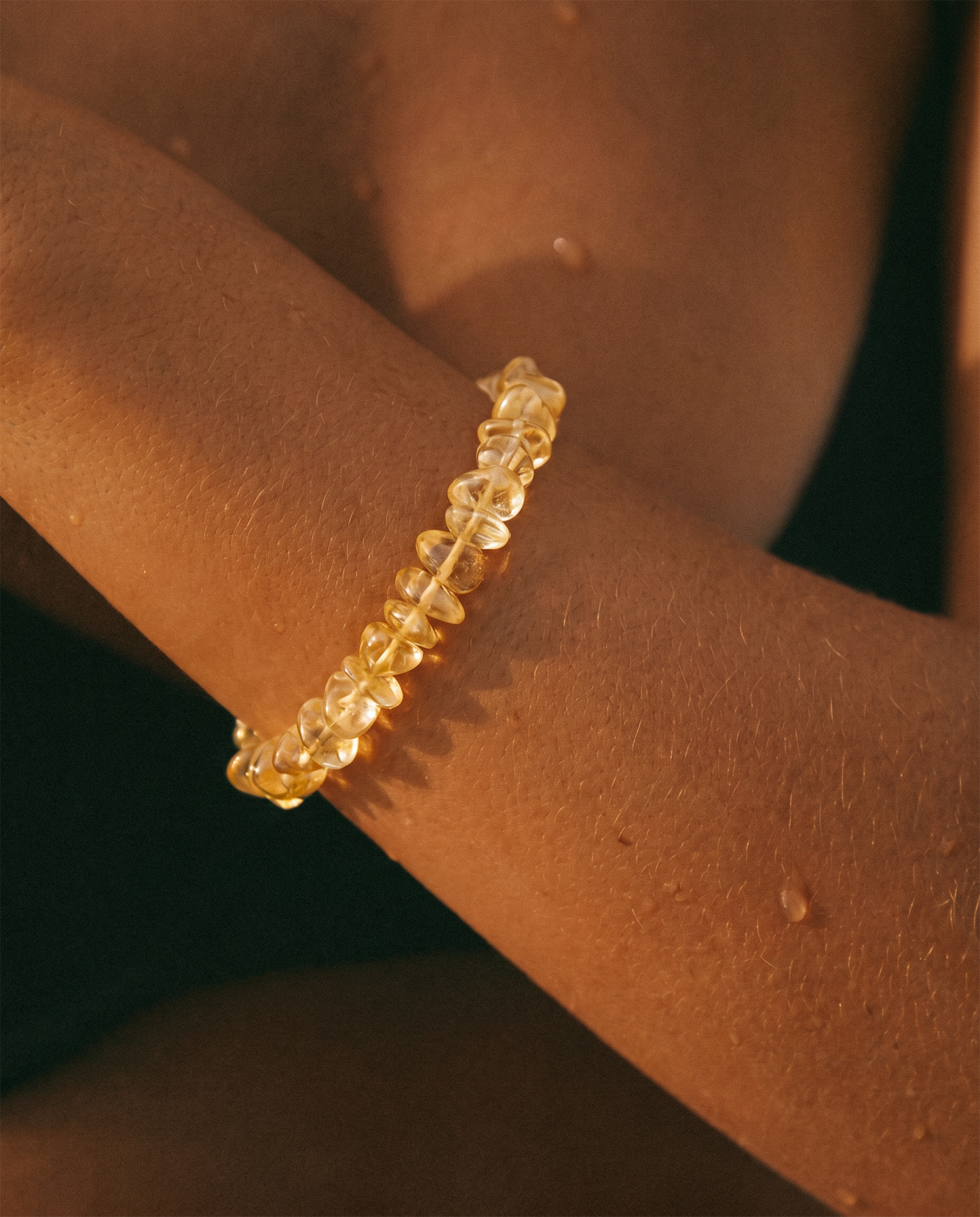 Gold bracelet on a wrist with a warm glow