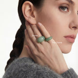 Woman wearing two green stone rings with text labels for the Dome ring and the Thin Dome ring