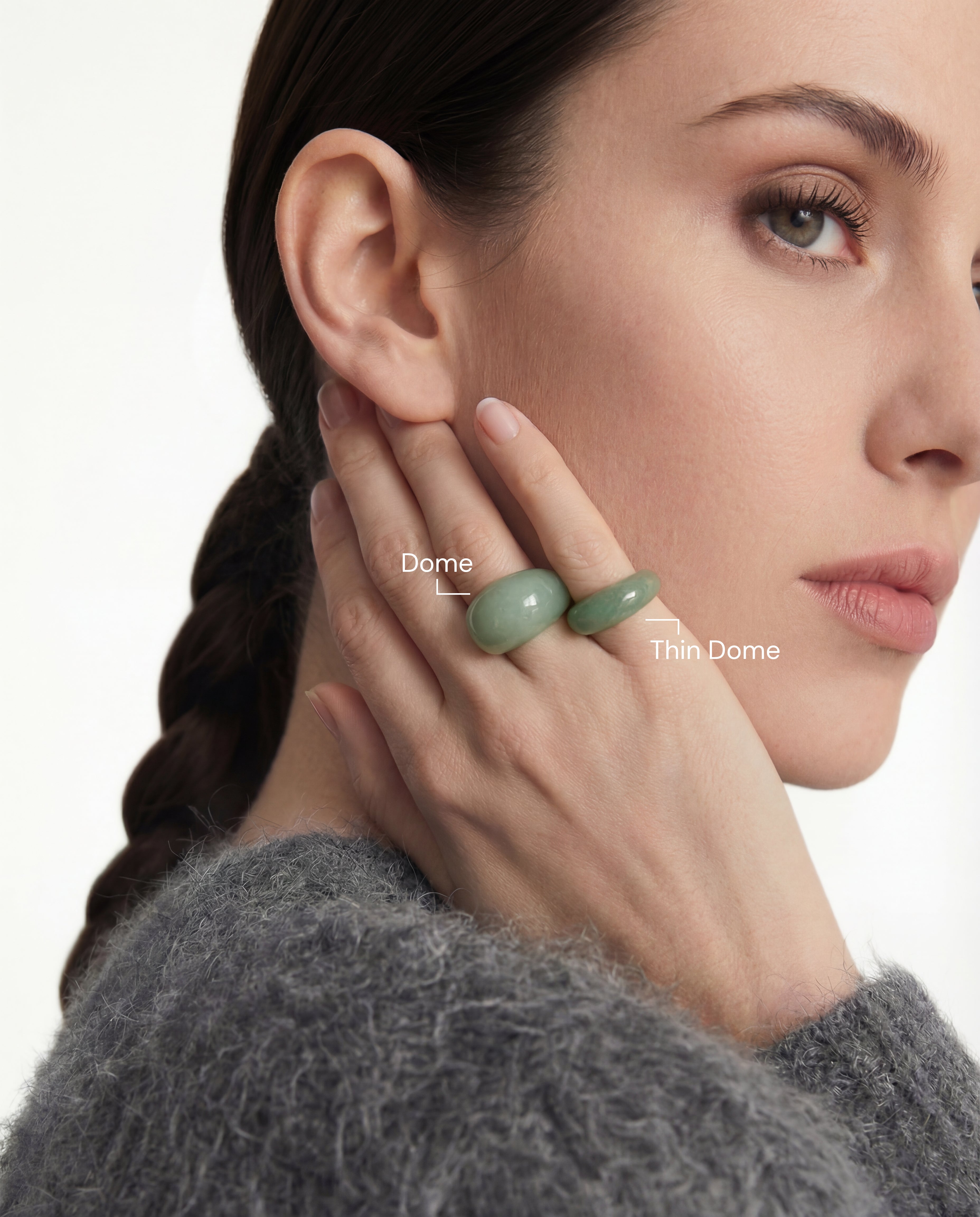 Woman wearing two green stone rings with text labels for the Dome ring and the Thin Dome ring