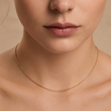 A woman wearing a skinny gold plated chain