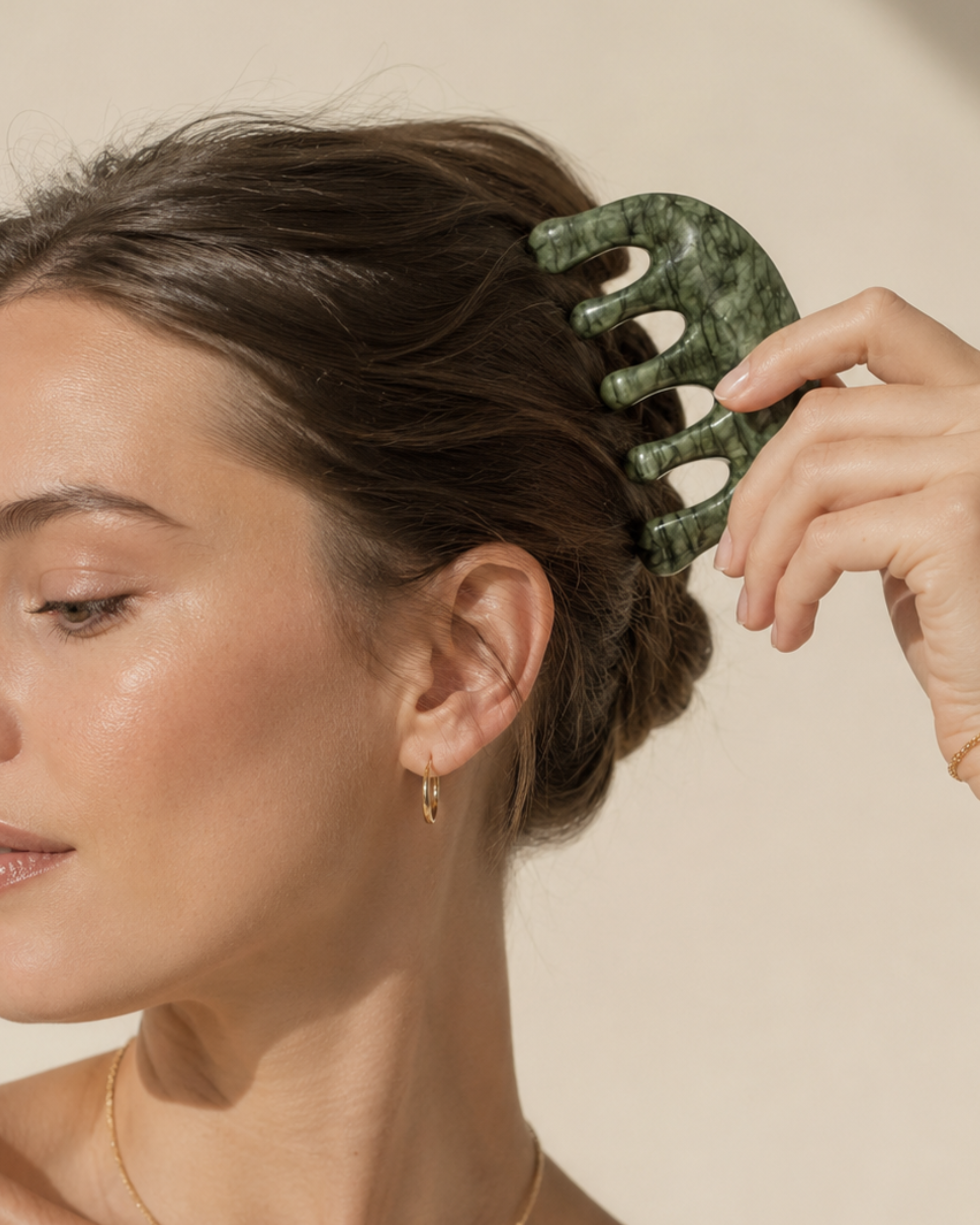 Person using a green hair comb on their hair against a neutral background