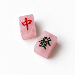 Two pink translucent stone tiles with Chinese characters, one marked in red and the other in black, on a clean white background.
