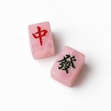Two pink translucent stone tiles with Chinese characters, one marked in red and the other in black, on a clean white background.