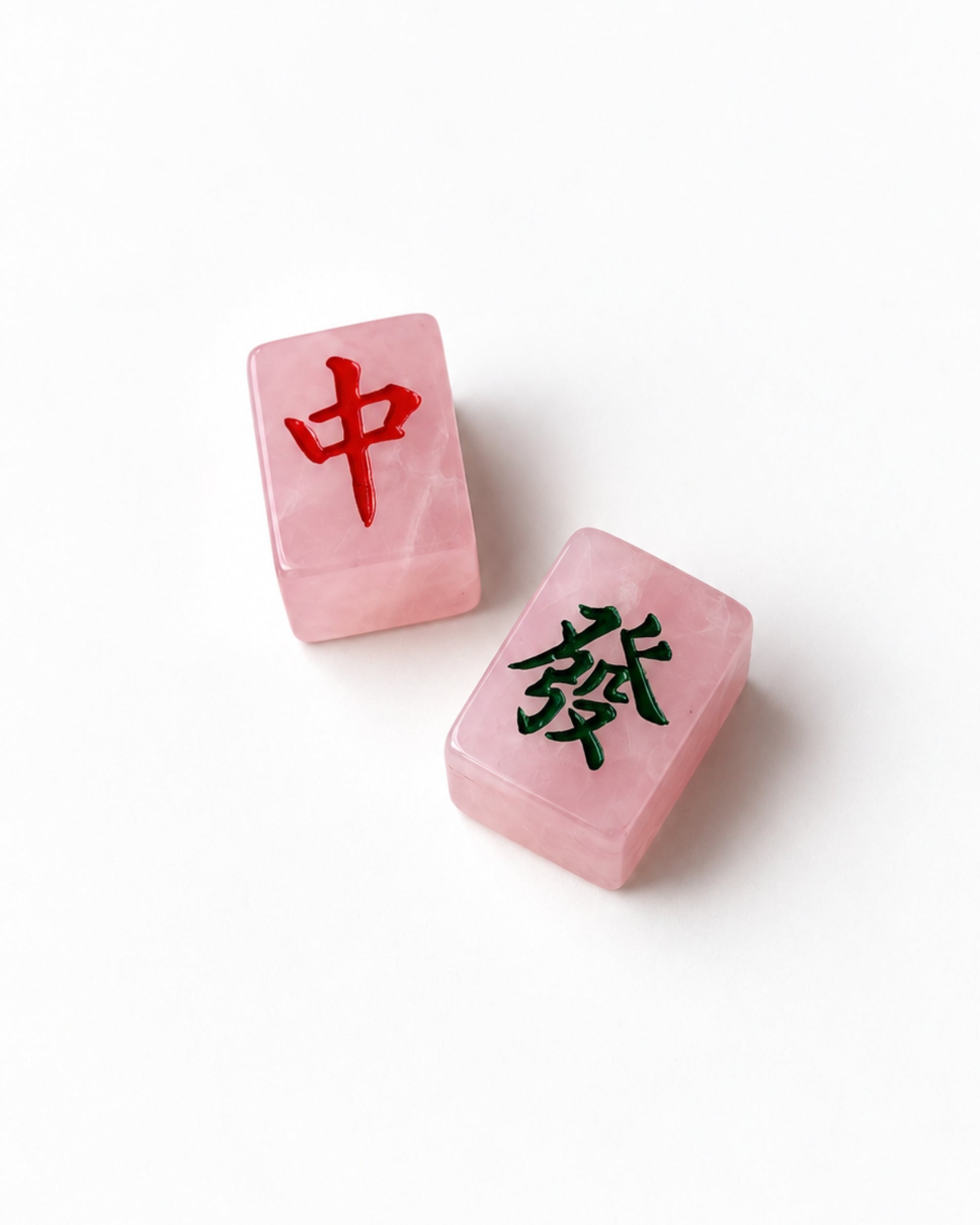 Two pink translucent stone tiles with Chinese characters, one marked in red and the other in black, on a clean white background.