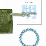Blue beaded bracelet with a green pouch and 'seree' card on a white background