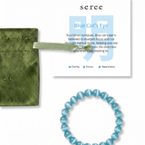 Blue beaded bracelet with a green pouch and 'seree' card on a white background