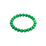 Slightly angled top-down view of a green cat's eye beaded bracelet on a white background