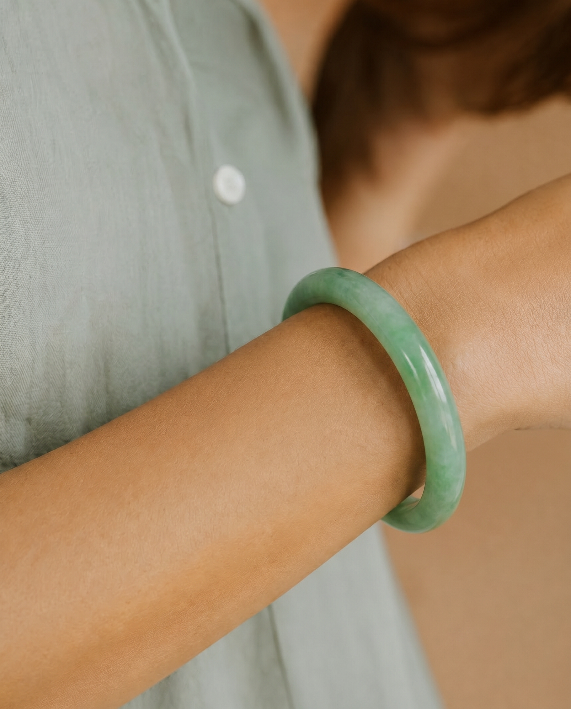 Person wearing a green bracelet on a blurred background
