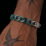 Teal chain bracelet on a wrist with tattoos