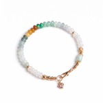 Multicolored beaded bracelet with a heart charm on a white background, top view