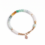 Multicolored beaded bracelet with a heart charm on a white background, top view