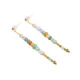 Pair of beaded earrings with gold accents on a white background