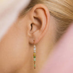 Close-up of an ear wearing a beaded earring with a blurred background