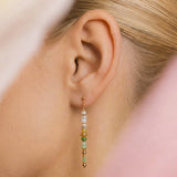 Close-up of an ear wearing a beaded earring with a blurred background