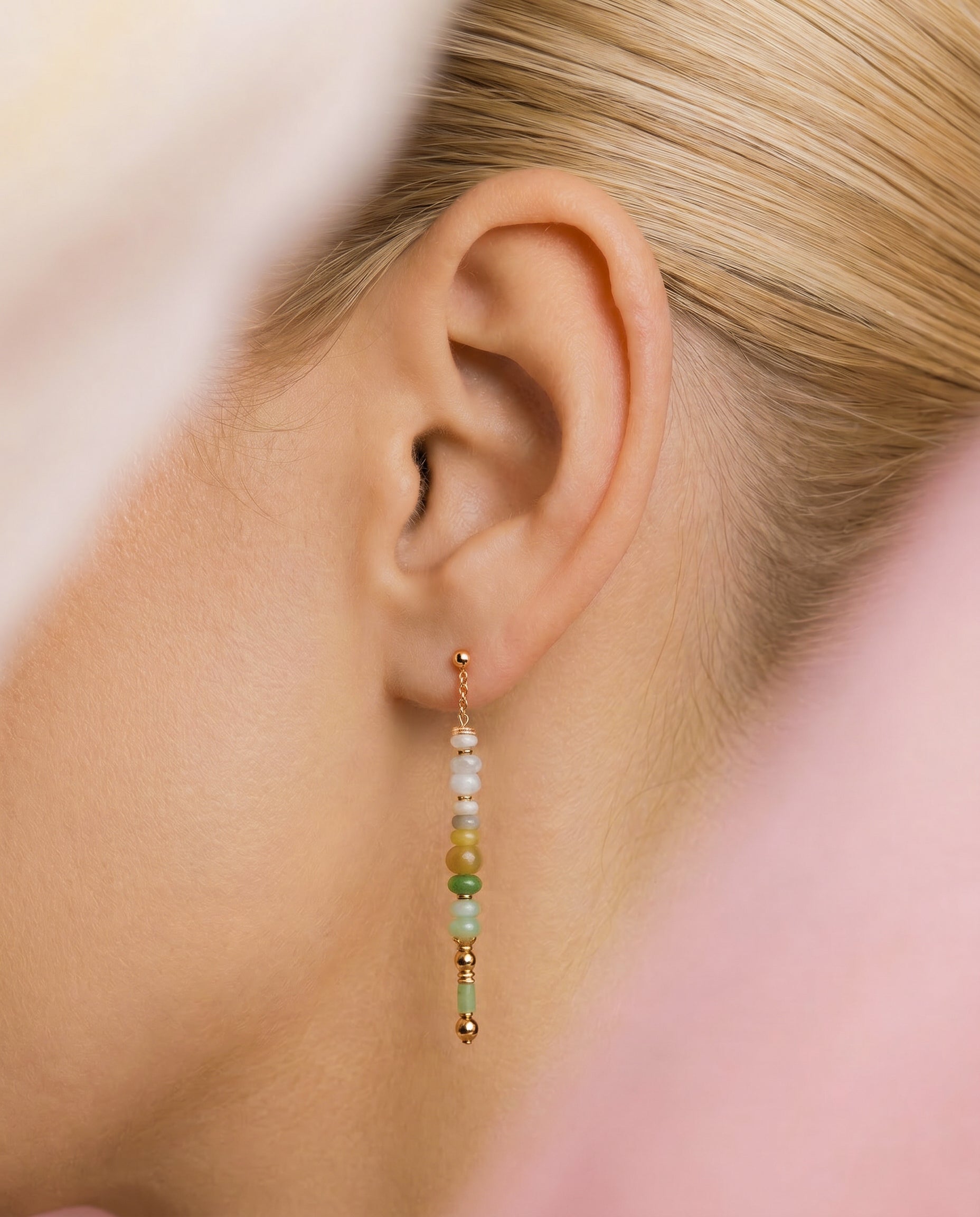 Close-up of an ear wearing a beaded earring with a blurred background