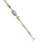 Close-up of green beaded bracelet with gold accents on a white background