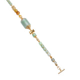 Close-up of green beaded bracelet with gold accents on a white background