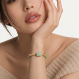 Woman wearing a green beaded bracelet on a white background