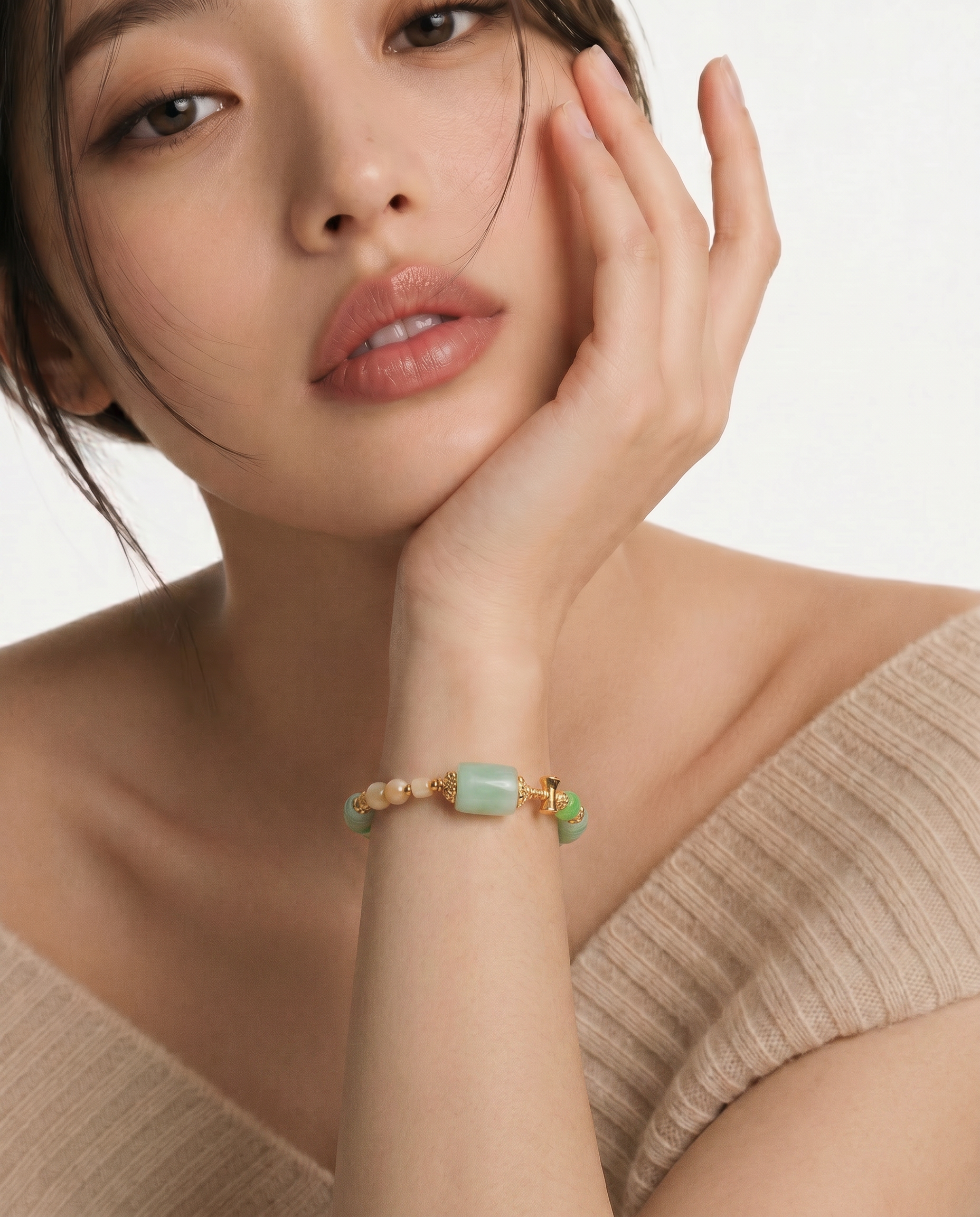 Woman wearing a green beaded bracelet on a white background