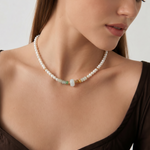 Woman wearing a pearl beaded necklace with a neutral background