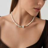 Woman wearing a pearl beaded necklace with a neutral background
