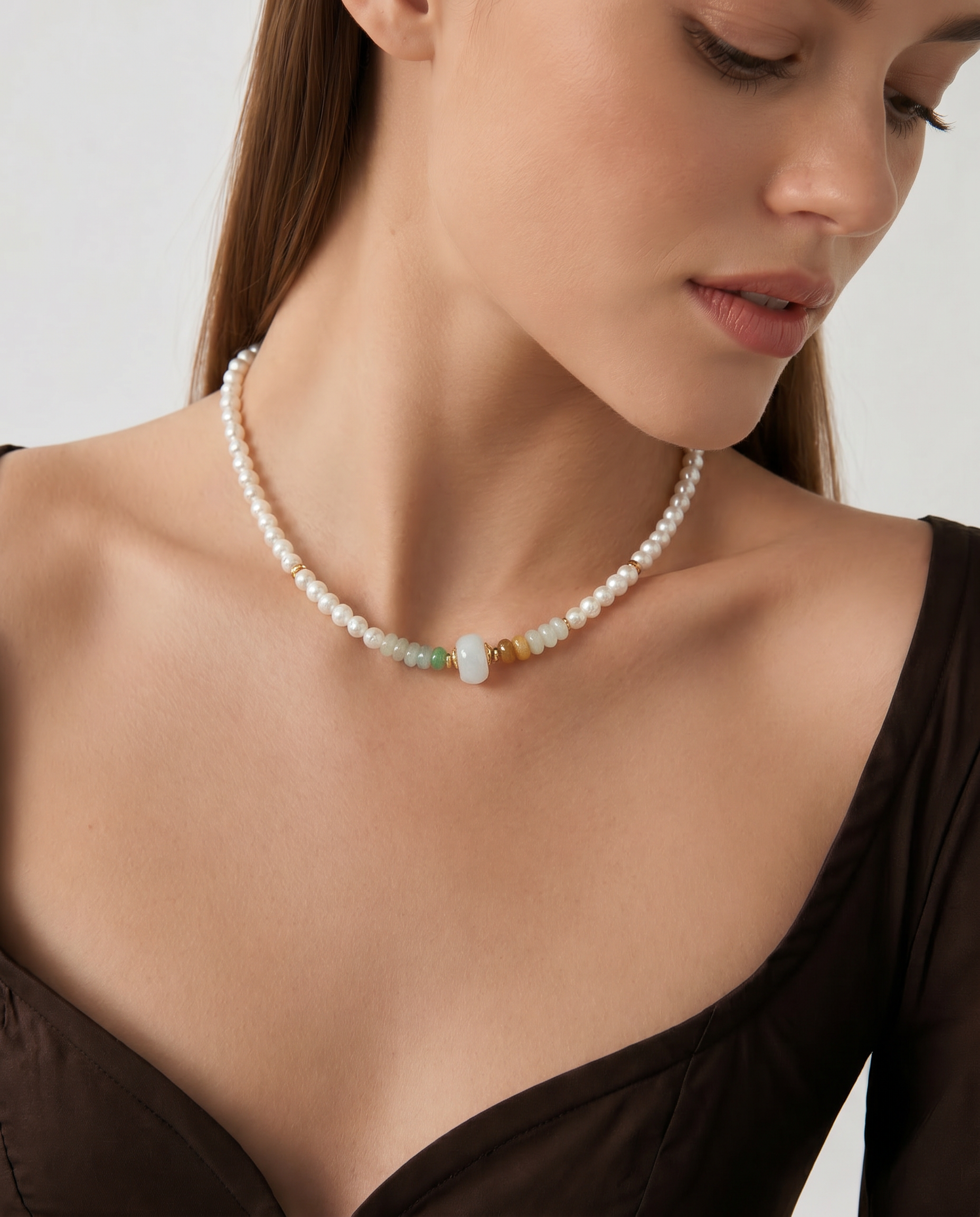 Woman wearing a pearl beaded necklace with a neutral background