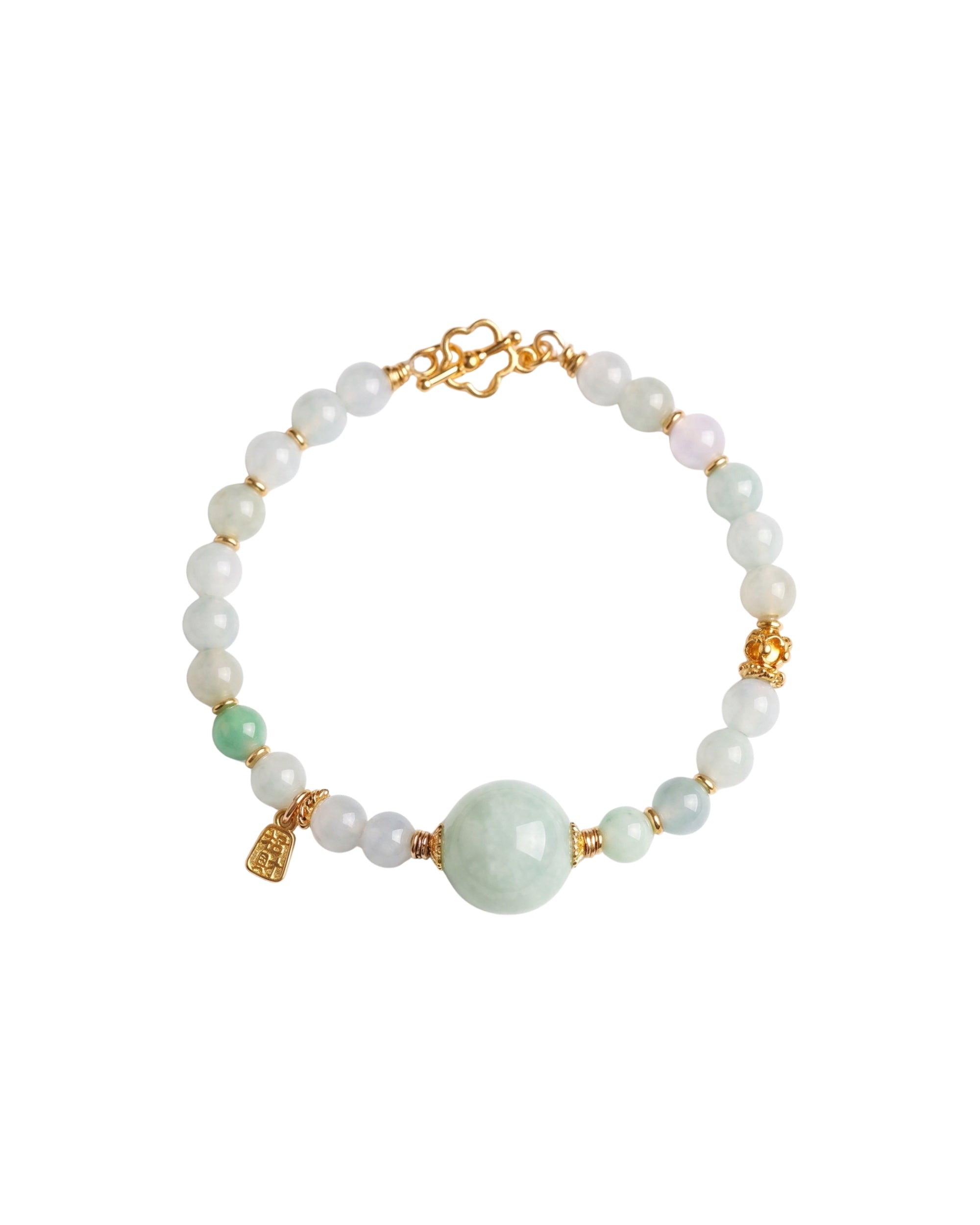 Bracelet with white and green jade beads and gold accents on a white background, top view
