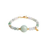 Bracelet with white and green jade beads and gold accents on a white background, front view