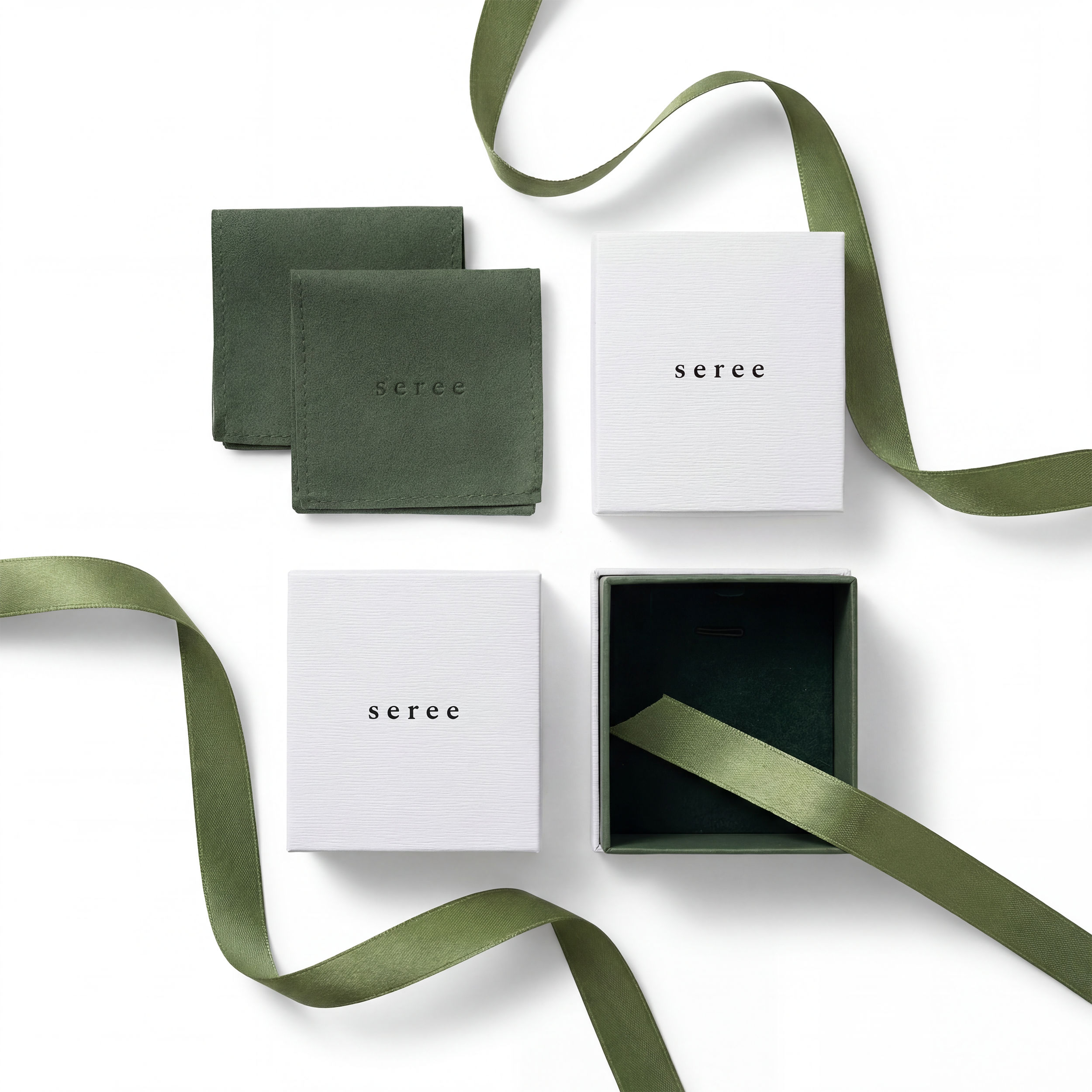 Green ribbons and white jewelry boxes with 'seree' branding on a white background, top view