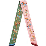 A green and pink scarf with carousel designs on a white background